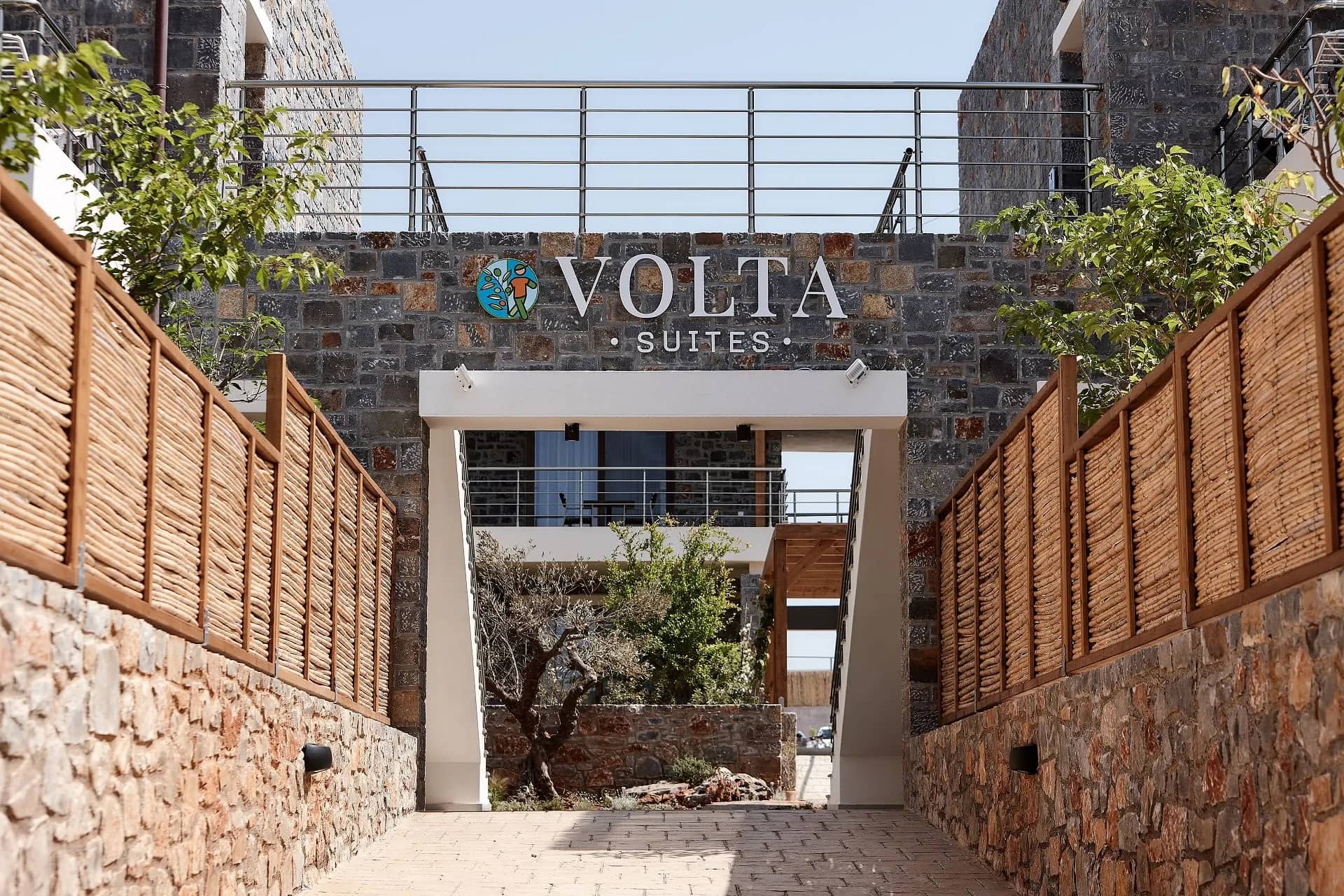 The stone entrance walk of Volta Suites and Villas with the Volta Suites sign