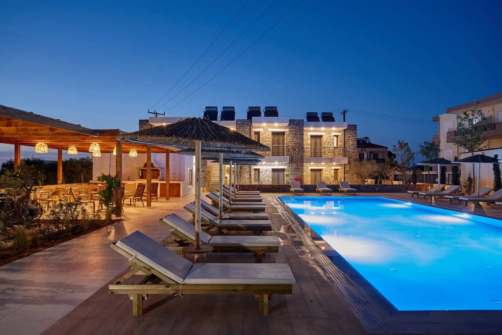Evening view of the pool and stone buildings of Volta Suites and Villas